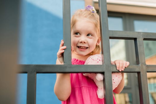 Happy cute child girl having fun outdoor in summer time. Children and generation alpha concept.