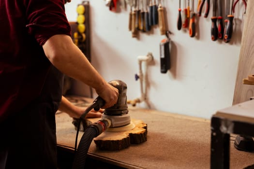 Carpenter using orbital sander with finer sandpaper grits to achieve smoother and more refined finish. Woodworker using angle grinder on wood, achieving professional quality results