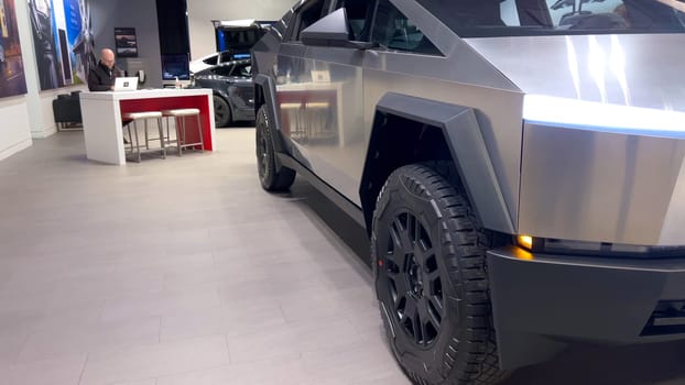 Colorado Springs, Colorado, USA-March 23, 2024-The futuristic Tesla Cybertruck takes center stage in the showroom of a Tesla store, with interested visitors and sleek car designs in the backdrop, all within the Park Meadows Mall.