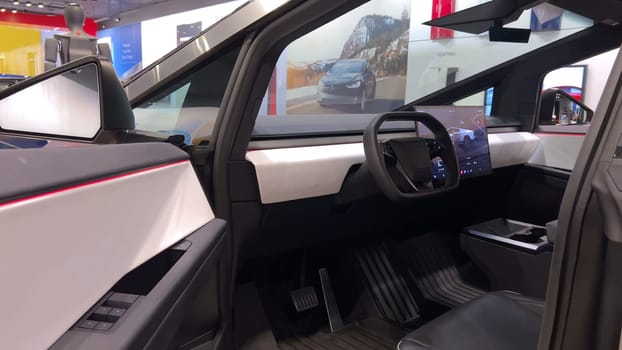 Colorado Springs, Colorado, USA-March 23, 2024-The futuristic Tesla Cybertruck takes center stage in the showroom of a Tesla store, with interested visitors and sleek car designs in the backdrop, all within the Park Meadows Mall.