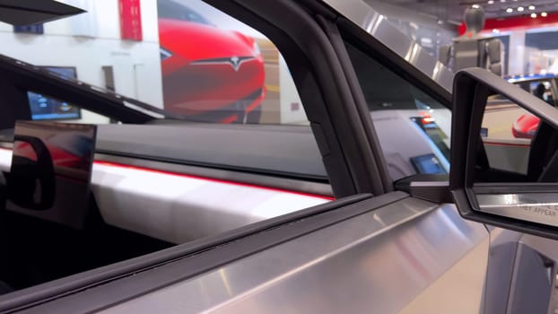 Colorado Springs, Colorado, USA-March 23, 2024-The futuristic Tesla Cybertruck takes center stage in the showroom of a Tesla store, with interested visitors and sleek car designs in the backdrop, all within the Park Meadows Mall.