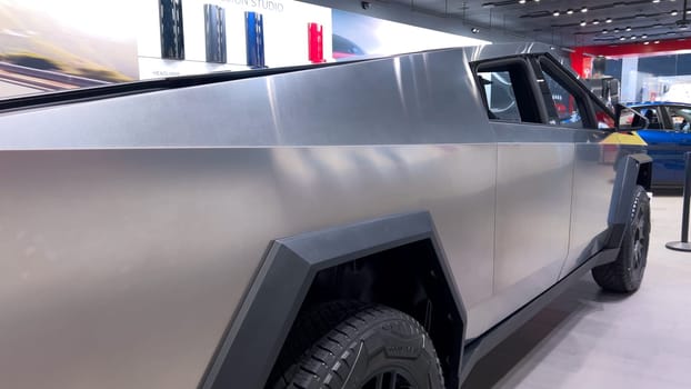 Colorado Springs, Colorado, USA-March 23, 2024-The futuristic Tesla Cybertruck takes center stage in the showroom of a Tesla store, with interested visitors and sleek car designs in the backdrop, all within the Park Meadows Mall.