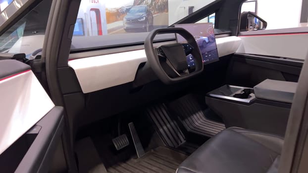 Colorado Springs, Colorado, USA-March 23, 2024-The futuristic Tesla Cybertruck takes center stage in the showroom of a Tesla store, with interested visitors and sleek car designs in the backdrop, all within the Park Meadows Mall.