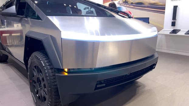 Colorado Springs, Colorado, USA-March 23, 2024-The futuristic Tesla Cybertruck takes center stage in the showroom of a Tesla store, with interested visitors and sleek car designs in the backdrop, all within the Park Meadows Mall.