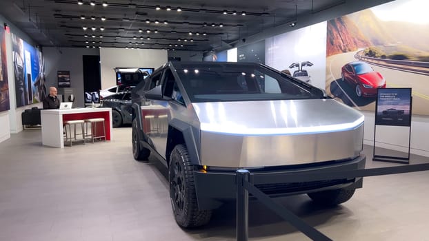 Colorado Springs, Colorado, USA-March 23, 2024-The futuristic Tesla Cybertruck takes center stage in the showroom of a Tesla store, with interested visitors and sleek car designs in the backdrop, all within the Park Meadows Mall.