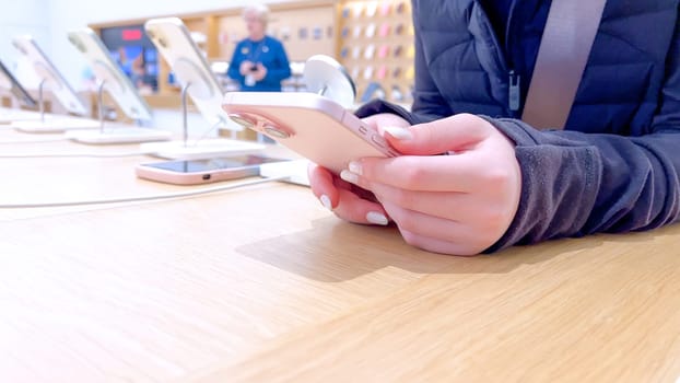 Denver, Colorado, USA-March 23, 2024-curious little girl examines the latest iPhone models on display at the Apple Store located in Park Meadows Mall, showcasing a youthful interest in technology.