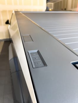 Denver, Colorado, USA-March 28, 2024-An up-close perspective of the Tesla Cybertruck unique angular design and control buttons, parked within the clean environment of a suburban home garage.