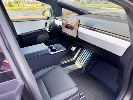 Denver, Colorado, USA-March 28, 2024-The cabin of the Tesla Cybertruck reveals a futuristic and minimalistic design, highlighting a spacious seating arrangement and a prominent, wide touchscreen display on the dashboard.