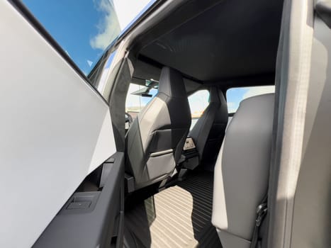 Denver, Colorado, USA-March 28, 2024-The interior shot of the Tesla Cybertruck showcases the roomy rear cabin with its modern, streamlined seats and durable flooring, reflecting the blend of utility and design.