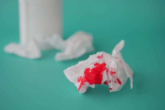 Blood on the tissues on light green background .