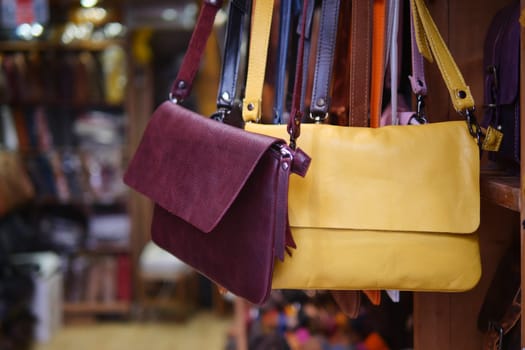 Close up of leather handmade bags on a wall for sale .