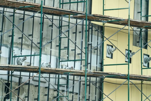 A building under construction with scaffolding and a lot of birds.