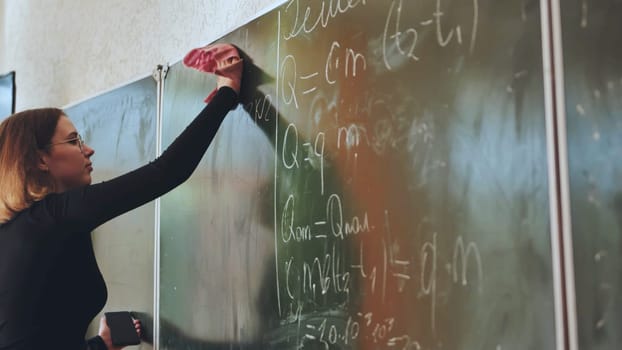 A girl washes the school blackboard after a maths lesson
