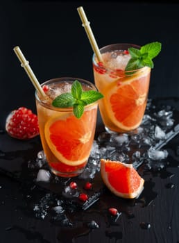 Grapefruit and pomegranate cocktail or mocktail, refreshing summer drink with crushed ice and sparkling water.