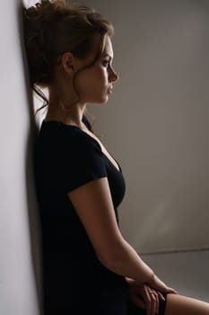 Profile of pretty brunette dressed in black casual dress
