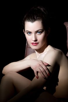 Studio portrait of nude model posing looking as femme fatale