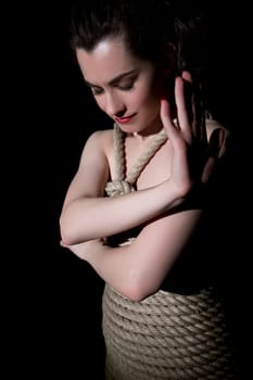 Kinbaku. Studio image of nude woman tied with jute rope