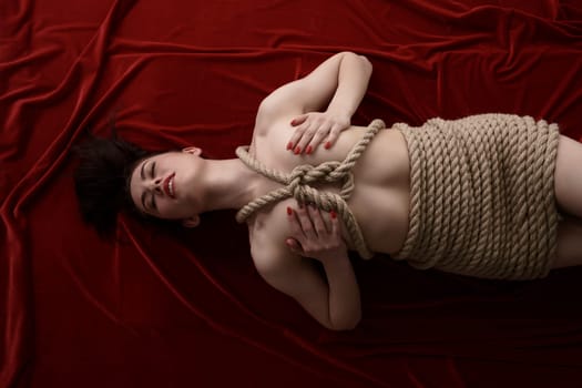 Bondage as sexual fetish. Top view of woman tied with rope