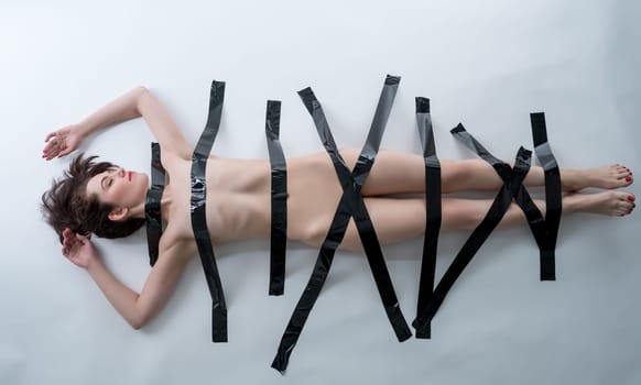 BDSM concept. Image of nude woman with black adhesive tape