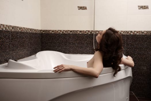 Image of pretty nude brunette enjoys taking bath