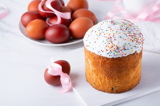 Delicious Easter cake and eggs on white background.