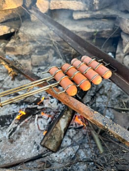 sausages roasting on a fire in summer