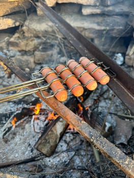 sausages roasting on a fire in summer