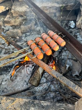 sausages roasting on a fire in summer