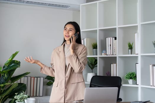 Business woman having phone conversation with client in office. young woman using smart phone. Woman Hands Using Mobile Phone in the Office.