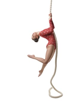 Studio photo of graceful female gymnast hanging on rope