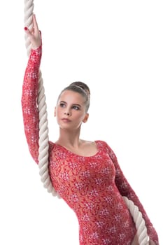 Studio photo of attractive dark-haired gymnast posing with rope