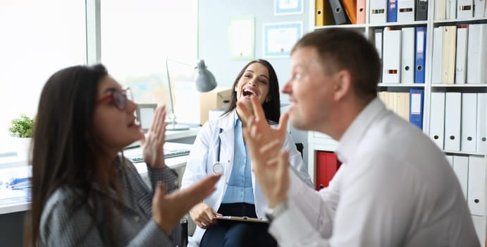 Doctor psychologist laughs in office at easy problems of young family. Position mismatch concept