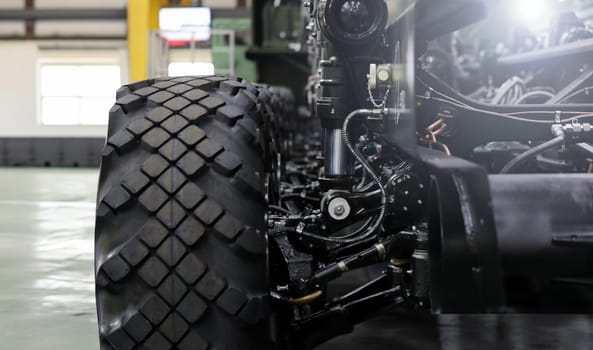 Close-up of new suspension system and shock absorber of car with wheel. Automotive part of atv off road. Mechanical engineering industry concept. Blurred background