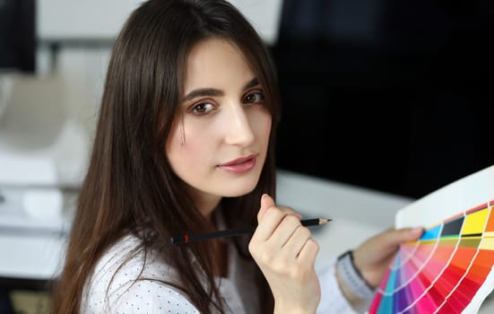 Pretty caucasian adult woman picking color using fantail palette headshot