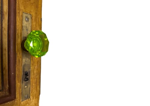 Classic green glass door knob with detailed design on wooden door.