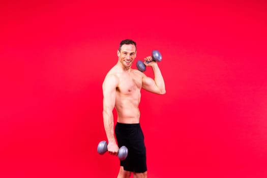 Exercising weight training man with dumbbell isolated on studio background, sport and fitness concept