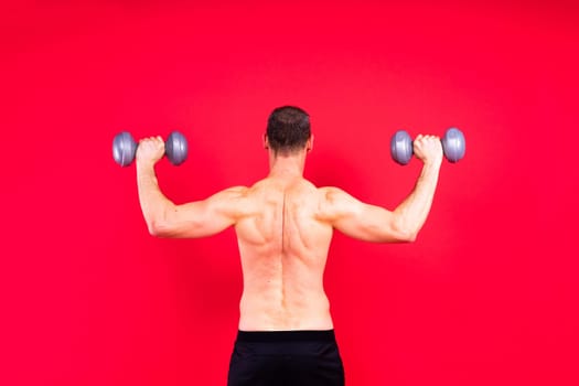 Exercising weight training man with dumbbell isolated on studio background, sport and fitness concept