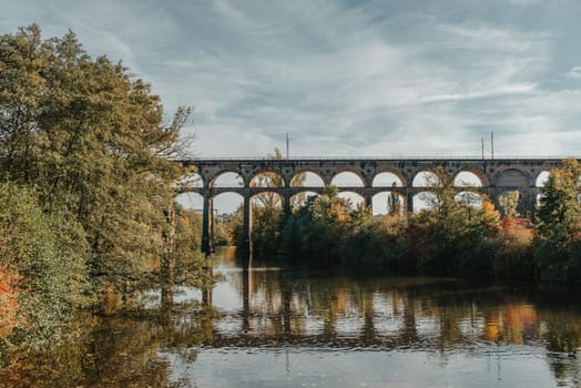 Railway Bridge with river in Bietigheim-Bissingen, Germany. Autumn. Railway viaduct over the Enz River, built in 1853 by Karl von Etzel on a sunny summer day. Bietigheim-Bissingen, Germany. Old viaduct in Bietigheim reflected in the river. Baden-Wurttemberg, Germany. Train passing a train bridge on a cloudy day in Germany