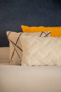 Colorful cushions on bed in illuminated room.