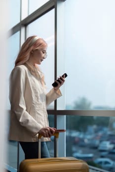 A woman asian walking in an airport. Mobile, suitcase and travel with a young female on an trip for work or travel.