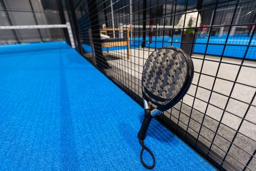 paddle tennis racket and balls on the blue paddle court. High quality photo
