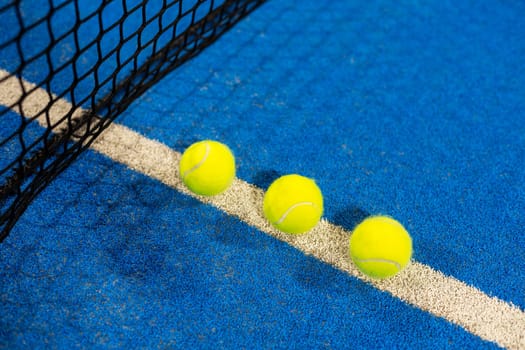 paddle tennis racket and balls on the blue paddle court. High quality photo