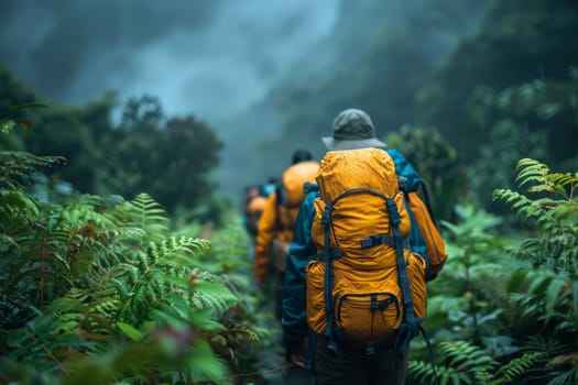 A group of people are hiking through a forest wearing orange backpacks. Scene is adventurous and exciting, as the group is trekking through the wilderness