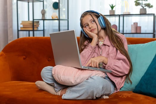 Tired young pupil girl student feeling boring with study or work at home. Stressed female teenage child exhausted from remote distance online education learning hard program on laptop computer indoors