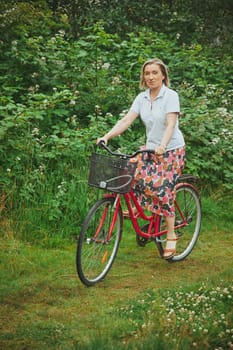 Aalborg, Denmark, July 23, 2022: Beautiful mature woman riding a bicycle
