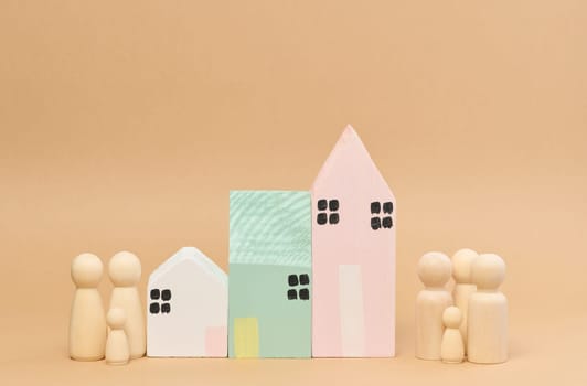 Wooden houses and wooden men of a family with children. Concept of searching for rental housing, mortgage