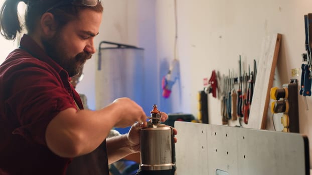 Mechanic in carpentry shop changing rotor part on spindle moulder machinery. Repairman in joinery fixing broken wood shaper, replacing damaged component, camera A close up shot