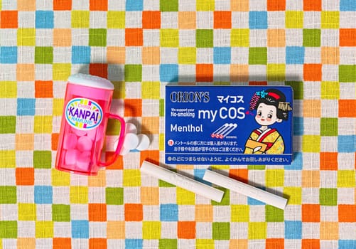tokyo, japan - fev 17 2024: Top view photo of Japanese confectionery manufacturer Orion's dagashi penny candies featuring cocoa cigarettes pack and a beer mug for kids pretending to smoke or drink.