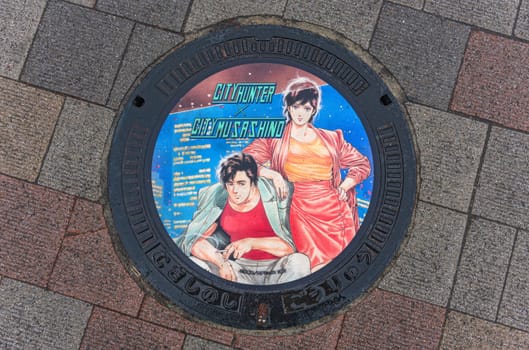 tokyo, japan - apr 25 2024: Wet manhole illustrated with the heroes of the Japanese manga and TV series City Hunter or Nicky Larson illustrated by Tsukasa Hojo for the City of Musashino in Kichijōji.