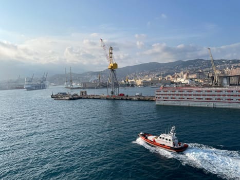 wide panoramic view of the harbor of Genoa. Blue sky blue sea white clouds and port buildings in harmony with the surrounding Mediterranean landscape High quality photo